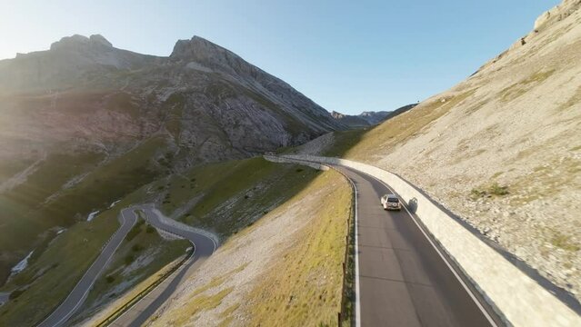 areal footage of following car going hill sunny summer day in high alp mountains epic view and drive 