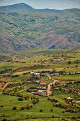 Distant view of a village among green hills in spring