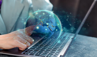 Hombre trabajando en su laptop con el dedo alzado de una de sus manos tocando el mundo digital totalmente conectado. - obrazy, fototapety, plakaty
