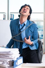 Chained male employee unhappy with excessive work