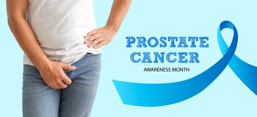 Man feeling discomfort, ribbon and text PROSTATE CANCER AWARENESS MONTH on light blue background