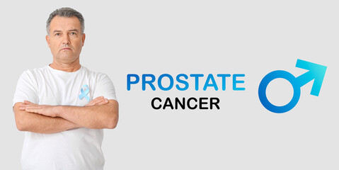 Mature man with light blue ribbon on grey background. Prostate Cancer Awareness