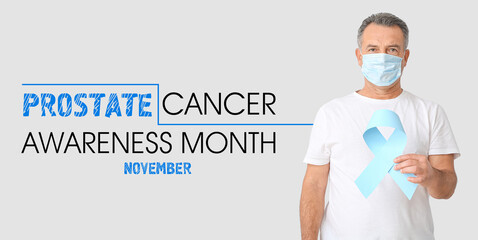 Mature man with light blue ribbon on grey background. November is a Prostate Cancer Awareness Month
