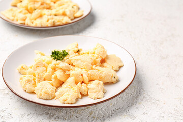 Plates of scrambled eggs on light textured background