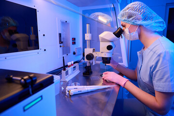 Female scientist involved in cell aspiration in laboratory