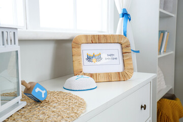 Greeting card for Hannukah with Jewish hat on commode in room, closeup