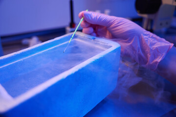 Embryologist performing embryo cryopreservation procedure in lab