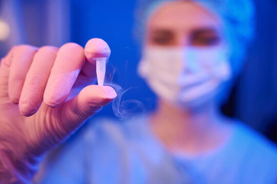 Lab scientist demonstrating cryogenic vial with frozen female egg samples