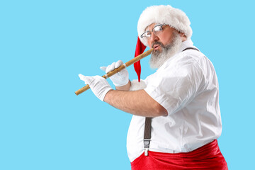 Cool Santa Claus playing with woodwind instrument on blue background