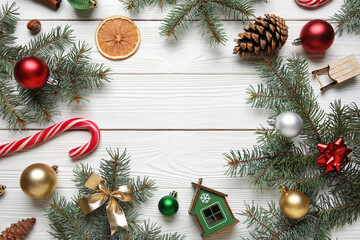 Beautiful fir branches with Christmas decorations on white wooden background