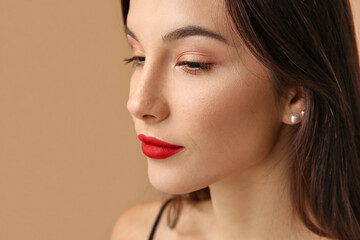 Fototapeta premium Beautiful young woman with eyeshadows on brown background