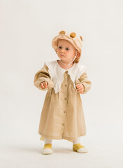 portrait of a little girl in a dress on a white background. a cute girl in a dress looks at something