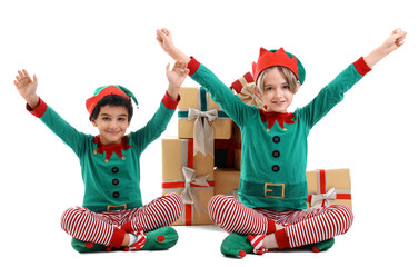 Cute little children in elves costumes with gift boxes isolated on green background
