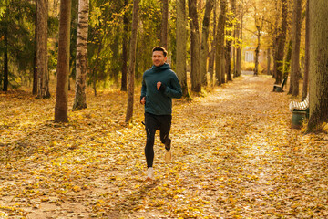 Athlete training every day and in winter. Beautiful bright autumn colors. A man in warm sports...