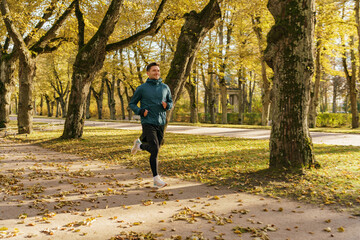 Jogging, warm-up every day, healthy lifestyle. Man training in the afternoon in the autumn cold season. An athlete in sports shoes and warm clothes for fitness.