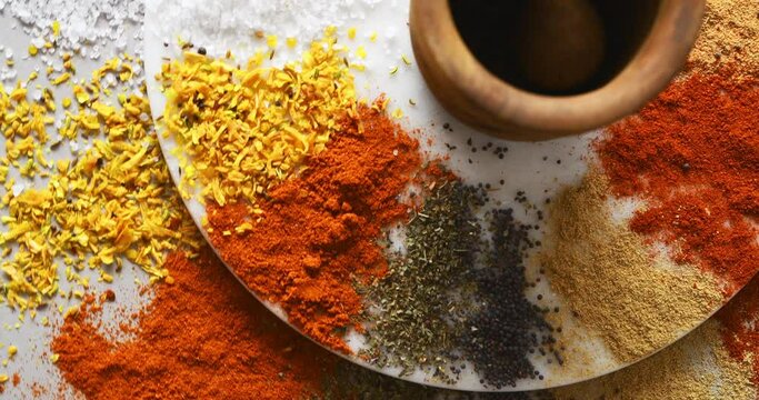 Spices, herbs and powder on table in kitchen for cooking, food or seasoning collection with color. Top View, curry and tumeric or salt with colorful seeds, cumin and masala on arrangement board