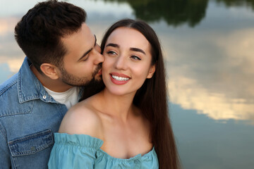 Obraz premium Romantic date. Beautiful couple spending time together near lake