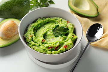 Delicious guacamole with avocado served on white table