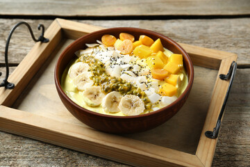 Tasty smoothie bowl with fresh fruits on wooden table