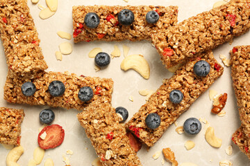 Tasty granola bars, blueberries and nuts on beige marble table, flat lay