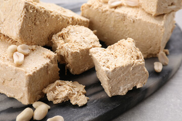 Pieces of tasty halva on dark gray marble board, closeup