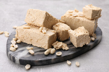 Pieces of tasty halva on light gray table, closeup