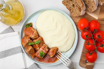Delicious goulash served with mashed potato on white table, flat lay