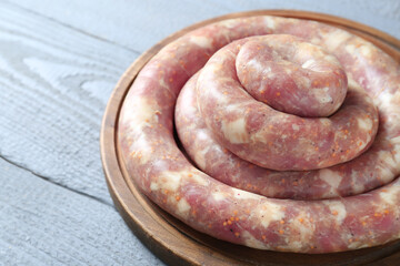 Homemade sausages on light grey wooden table, closeup