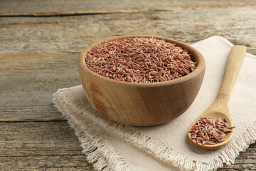 Bowl of caraway seeds and spoon on wooden table, space for text