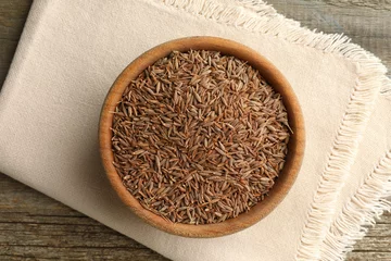 Fotobehang Bowl of caraway seeds and napkin on wooden table, top view © New Africa