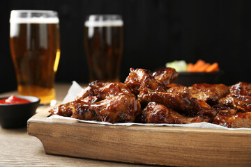 Tasty chicken wings on wooden table, closeup. Beer snack