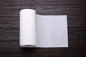 Roll of tissue towels on wooden table, top view