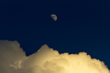 Moon and clouds in the blue sky at night, natural background.