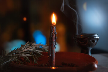 traditional ritual with fire and black candle in clay plate accompanied by pepper, sea salt, herbs...