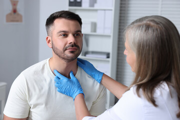 Endocrinologist examining thyroid gland of patient at hospital