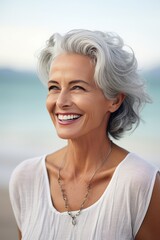 Portrait of a beautiful senior woman smiling at the camera on the beach