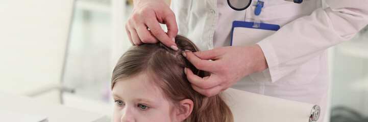 Therapist looks for insects in hair of little patient