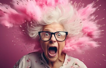 Fotobehang A vibrant image of an animated elderly woman with glasses, looking surprised as her hair erupts in a pink explosion. Ideal for fun campaigns, events, or senior-themed projects. © StockWorld