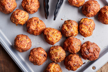 Top view of pork meatballs on a tray on wood background.