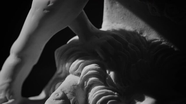 Closeup view of the base of the marble sculpture of Hercules and Lichas rotating on black background