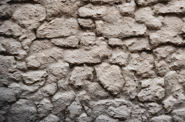 The surface of a wall composed of textured stone wall, creating a rustic and visually appealing...