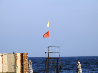 Yellow and red flags on the beach, beach warning flag system, red flag means High risk, rough...