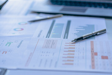 Office desk with report page, supplies and flat lay computer. with financial graph data on table in office