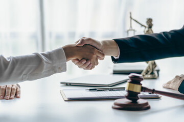 A lawyer shakes hands with a businessman to close a deal with a lawyer to discuss the contractual terms of the agreement. In the contract. Close-up photo.