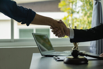 A lawyer shakes hands with a businessman to close a deal with a lawyer to discuss the contractual...
