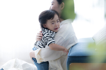 Fototapeta premium Mother carrying her baby in her arms Childcare is very difficult Crying baby