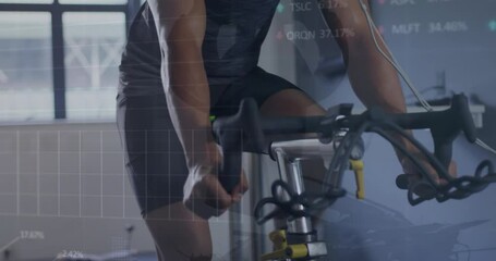 Animation of stock market data processing over biracial fit man training on exercise bike at the gym - Powered by Adobe