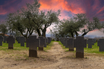 Tombstones and crosses in cemetery with trees. spectacular sky