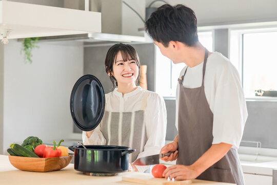 キッチンで料理・家事をする若いアジア人夫婦・カップル（自炊・共働き・家事分担）
