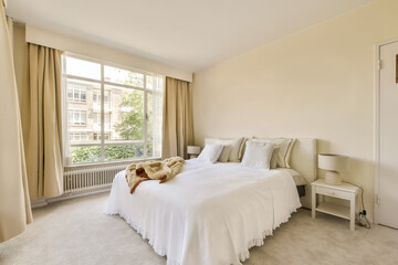 a bedroom with a bed, window and rugs on the floor in front of the bed is a teddy bear